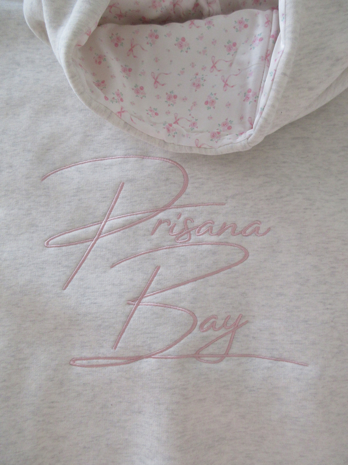 Sudadera Gris Jaspeada con Lazo Bordado Cómoda para Mujer con Capucha, Manga Larga, Forro Floral y Estilo Oversize de Punto