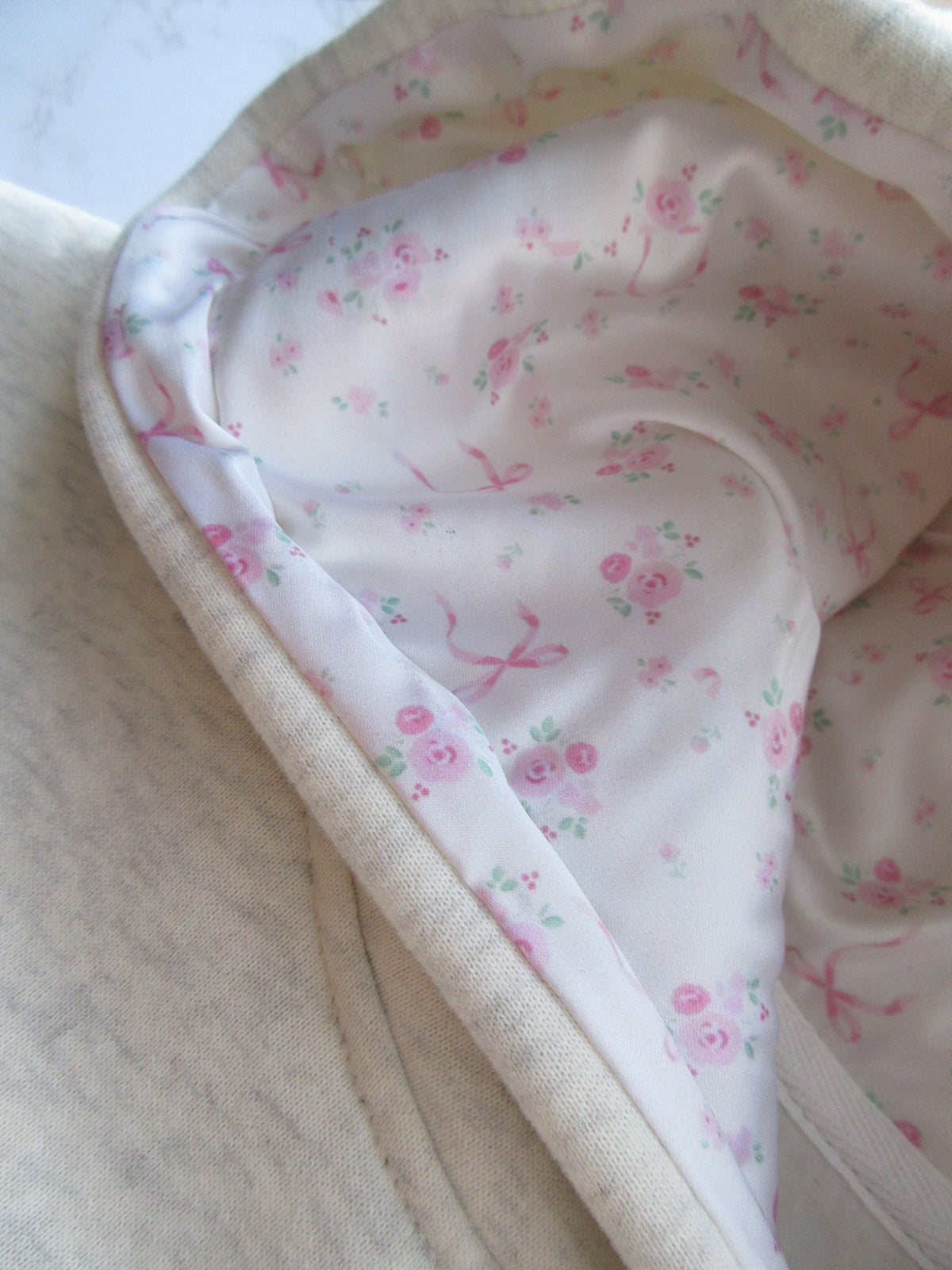 Sudadera Gris Jaspeada con Lazo Bordado Cómoda para Mujer con Capucha, Manga Larga, Forro Floral y Estilo Oversize de Punto